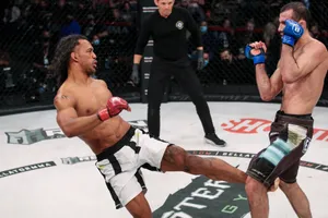 Ben Henderson Executing A High Inside Kick Against Islam Mamedov In An Mma Match Wallpaper
