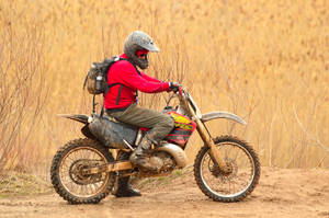 Bike Rider On A Dirt Road Wallpaper