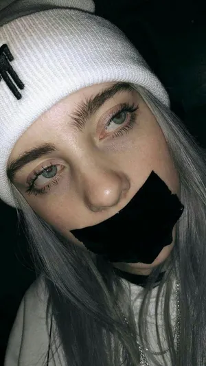 Billie Eilish Sad Expression With Tape Over Mouth Wallpaper