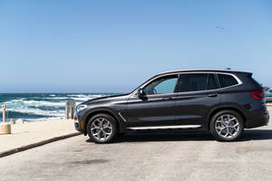 Black Bmw Parked At The Beach Wallpaper