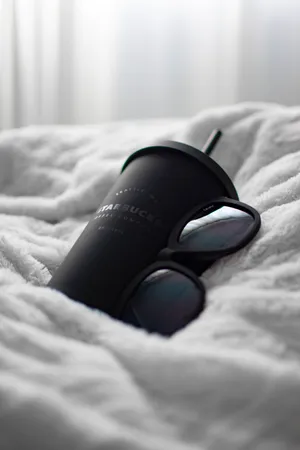 Black Camera Lens On White Textile Wallpaper