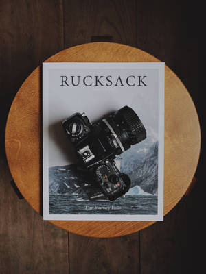 Black Dslr Camera On Rucksack Book Wallpaper