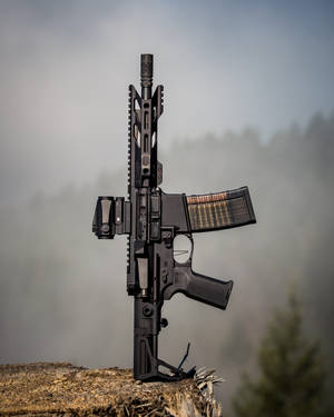 Black Rifle With Scope On Brown Soil Wallpaper