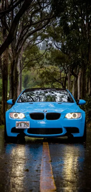 Blue Bmw In Tree-covered Pathway Wallpaper