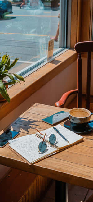 Cafe Table With Coffee And Notebook Wallpaper