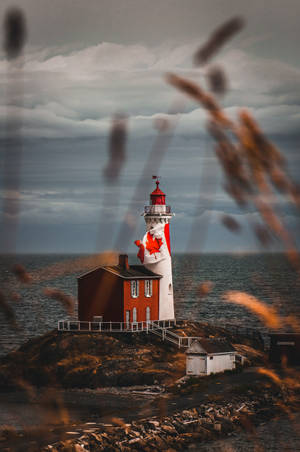 Canadian Lighthouse On Green Grass Field Wallpaper