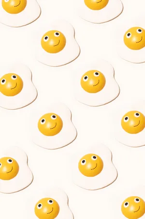 Caption: A Lively Smile Emoji Blended With Sunny Side Up Egg Wallpaper