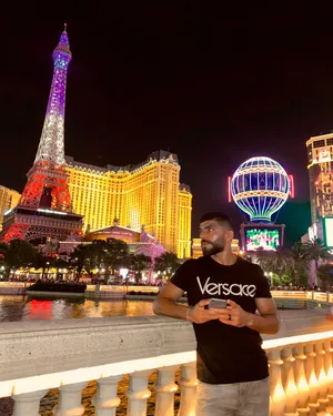 Caption: Amir Albazi Posing Beside An Eiffel Tower Replica Wallpaper