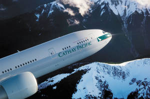 Caption: Cathay Pacific Jet Over Snow-capped Mountains Wallpaper