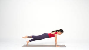 Caption: Dedicated Female Practicing Pilates Exercises Wallpaper