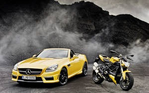 Caption: Elegance In Motion: Yellow Convertible Luxury Car Wallpaper