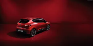 Caption: Elegant Red Renault Clio On Road Wallpaper