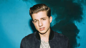 Caption: Exceptional Talent, Charlie Puth In A Misty Backdrop Wallpaper