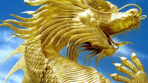 Caption: Majestic Golden Dragon Sculpture Wallpaper