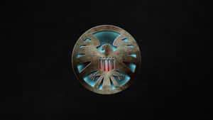 Caption: Majestic Golden Shield On A Dark Background Wallpaper