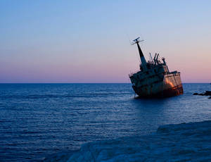 Caption: Majestic Sailing Ship In Deep Blue Ocean Wallpaper