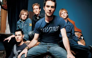 Caption: Maroon 5 Band Members In Blue Ensemble In A Blue Room Wallpaper
