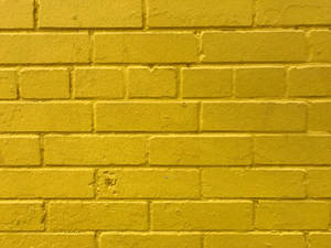 Caption: Radiant Golden Brick Wall Wallpaper