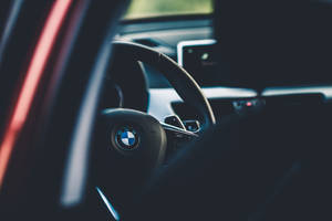 Caption: Sleek Black Bmw Cruising In The City Wallpaper