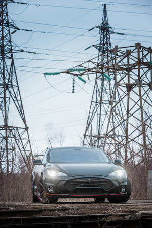 Caption: Tesla Model S Illuminating The Night With Bright Headlights Wallpaper