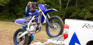 Caption: Thrilling Escape - Dirt Bike Loaded On Truck Wallpaper