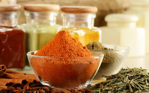 Caption: Vibrantly Colored Spices And Herbs In Glass Containers Wallpaper