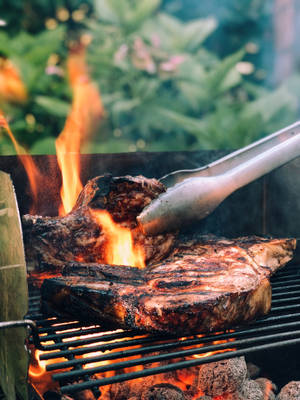 Capturing The Charm Of Authentic Steak Parrilla Grilling Outdoors Wallpaper