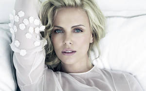 Charlize Theron Relaxing On White Pillows Wallpaper