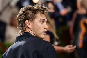 Charming Austin Butler Glancing Back With An Intense Gaze Wallpaper