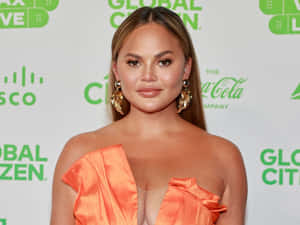 Chrissy Teigen Orange Dress Global Citizen Event Wallpaper