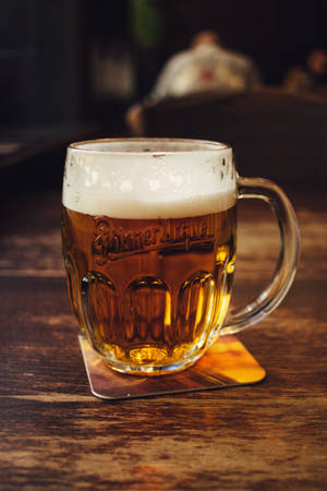 Clear Glass Beer Mug On Brown Wooden Table Wallpaper