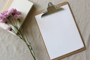 Clipboard And Flowers On Wooden Background Wallpaper