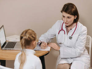 Compassionate Female Physician In Her Office Wallpaper