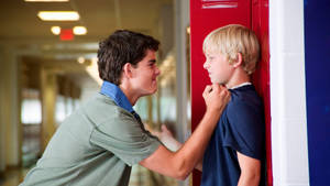 Confident Teen Boy Standing In Locker Room Wallpaper