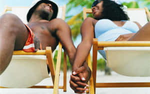 Couple At Beach On Reclining Chairs Wallpaper