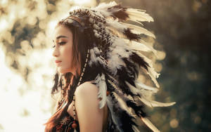 Cultural Fusion: Radiant Asian Woman Wearing Native American War Bonnet Wallpaper