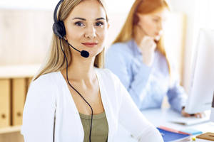 Customer Service Phone Operator Working At Her Desk Wallpaper