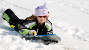 Cute Little Girl Sledding Wallpaper