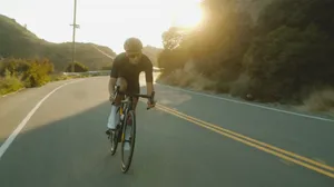 Cycling On Winding Road Wallpaper