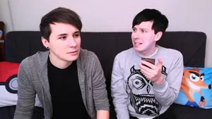 Dan And Phil Sitting On A Couch Wallpaper