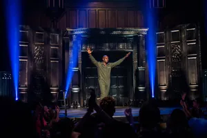 Dave Chappelle On Stage Delivering His Stand-up Comedy Performance Wallpaper