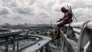 Deadpool - A Man Sitting On A Railing Wallpaper