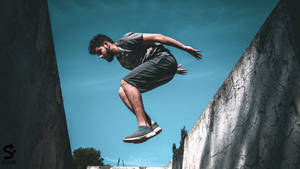 Defying Gravity: A Parkour Enthusiast In Mid-air Wallpaper