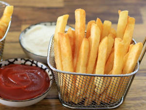 Delectable Golden French Fries In A Basket Wallpaper