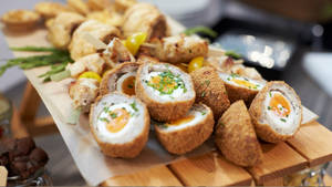 Delectable Traditional British Scotch Eggs With Sausage Rolls Wallpaper