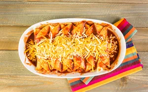 Delicious Enchilada Platter Topped With Cheddar Cheese. Wallpaper