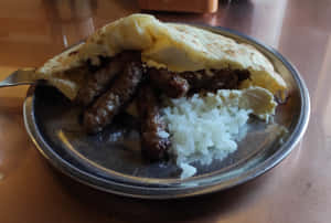 Delicious Grilled Ćevapi Inside Crisp Pita Bread Wallpaper