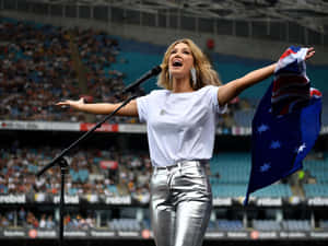 Delta Goodrem Singingwith Australian Flag Wallpaper