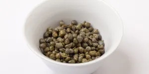 Dried Dark Green Capers In Bowl Wallpaper