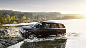 Driving Through Water In A Black Land Rover Wallpaper